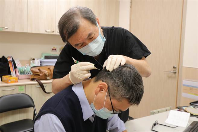 亚洲大学附属医院整形外科医师郑旭棠，为术后患者拆线。（亚大医院提供／林欣仪台中传真）