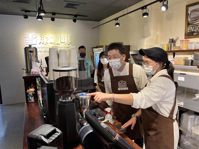 民眾党秘书长谢立功（中）化身一日店长试做咖啡。(蔡依珍摄)