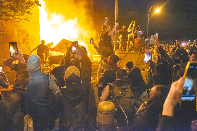 中国人民大学智库6日发布《十问美国民主》报告，并翻译成多国语言版本。图为2020年5月，明尼苏达州爆发示威活动，抗议美国警察执法不当导致非裔男子死亡。（新华社）