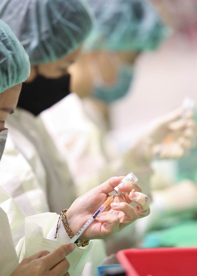 图为医护人员忙着抽取疫苗到注射筒。（示意图/资料照/陈俊吉摄）