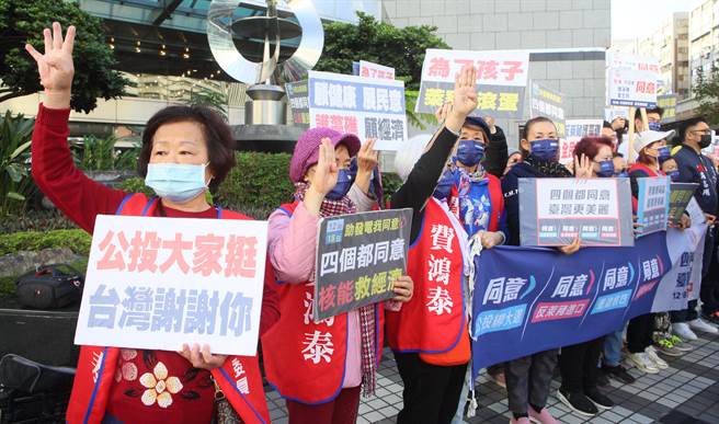 國民黨支持者8日發起「1218螞蟻雄兵 公投宣講」活動，在捷運站出口旁舉牌向民眾宣傳，呼籲大家4項公投案投下同意票。（張鎧乙攝）