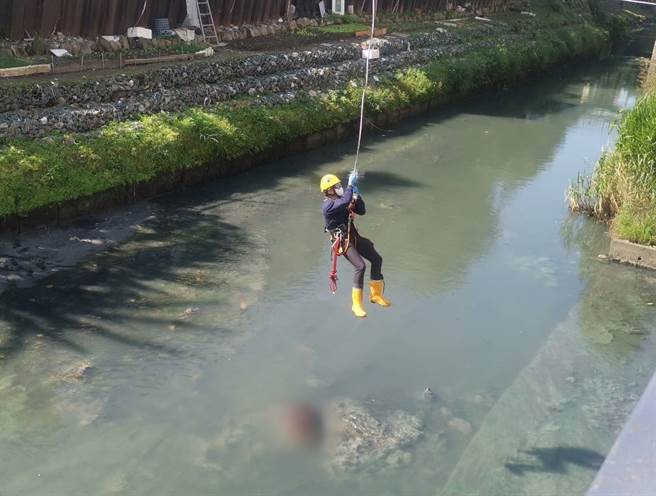 新北市永和区一处大排8日上午发生一具无头、无四肢遗体，消防人员获报后赶往现场吊挂遗体。（民眾提供）