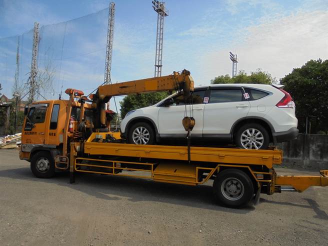 行政執行署嘉義分署執行官強制執行拖吊李男的車輛。（行政執行署嘉義分署提供）