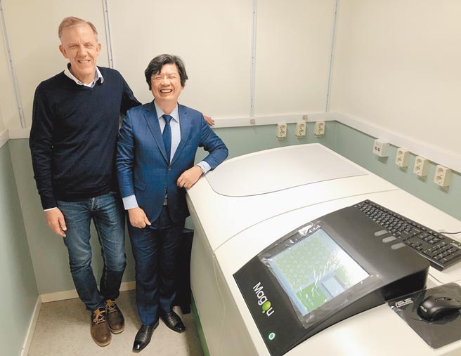 磁量生技总经理杨谢乐（右）与瑞典哥德堡大学医学院教授，兴奋在免疫磁减量失智症血液蛋白质分析仪前合影。图／磁量生技提供