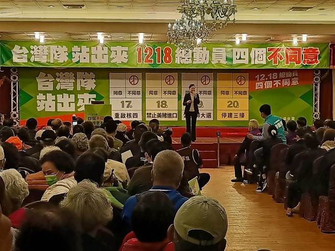 經濟部長王美花後方的大型背板，第十八案清楚寫著「禁止美豬進口」，顯然與真正的公投題目有所不同。（胡健森攝）