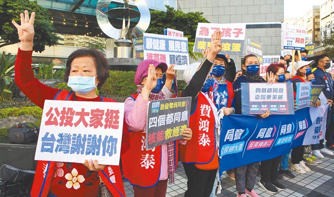 國民黨支持者8日發起「1218螞蟻雄兵 公投宣講」活動，在捷運站出口旁舉牌向民眾宣傳，呼籲大家4項公投案投下同意票。（張鎧乙攝）