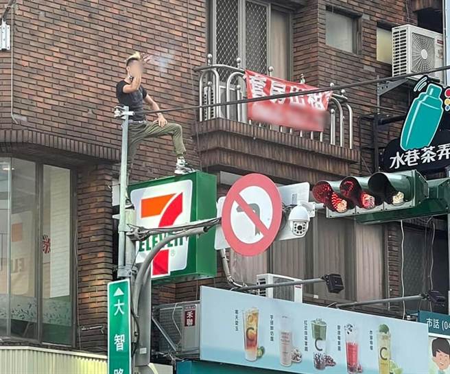 台中跳舞哥又出没，10日被网友目击爬上交通号志杆吞云吐雾。（翻摄自脸书社团《爆料公社》）