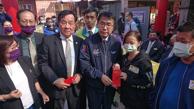 台南市長黃偉哲（中）與天壇董事長徐國潤（前排左二）一起頒發慰問金給自強戶民眾。（程炳璋攝）