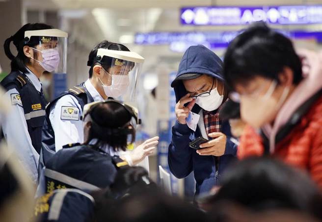 指揮中心證實，Omicron變異株已經侵台。在桃園機場入境管制區內，防疫人員協助旅客上網登錄入境檢疫資料（圖中非新聞當事人）。（范揚光攝）
