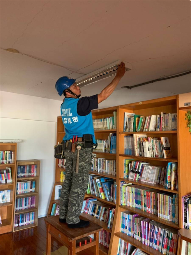 施工人員拆除和平國小校舍內的老舊燈具。（矽品提供／王文吉台中傳真）