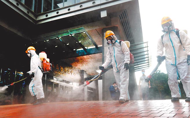 北市環保局人員進入中研院院區，對基因體研究中心大樓內外進行消毒。(鄭任南攝）