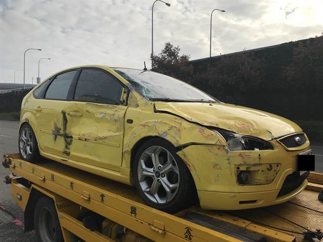 一部轿车12日上午在国道1号南向369公里近瑞隆路出口匝道被其他车辆超车波及，导致先撞内侧护栏再撞右侧的半联结车，车体毁损严重。（翻摄照片／林瑞益高雄报导）