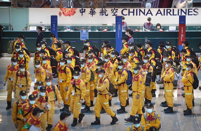 消防署首次演练搜救队搭乘包机出国值勤的假想状况。在第二航厦出境大厅内，搜救队员排队办理登机手续。（范扬光摄）
