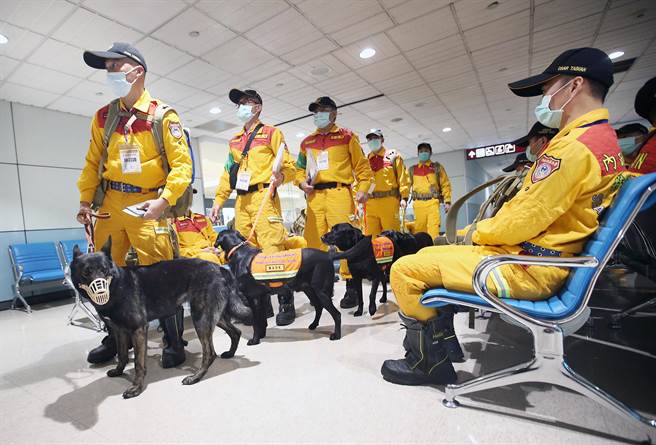 消防署首次演练搜救队搭乘包机出国值勤的假想状况。在候机室内，搜救队领犬员带着搜救犬准备登机。（范扬光摄）