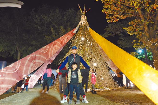 由枯木、染布做成的耶诞树藏有巧思，从各角度望去，顶端老人呈现不同表情，吸引民眾驻足拍照。（蔡旻妤摄）