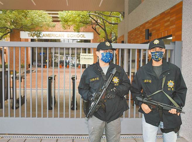 台北美国学校惊传收到不明人士的威胁扬言开枪，校方13日预防性停止上课一天，士林分局刑警持MP5衝锋枪站在校门警戒。（陈怡诚摄）