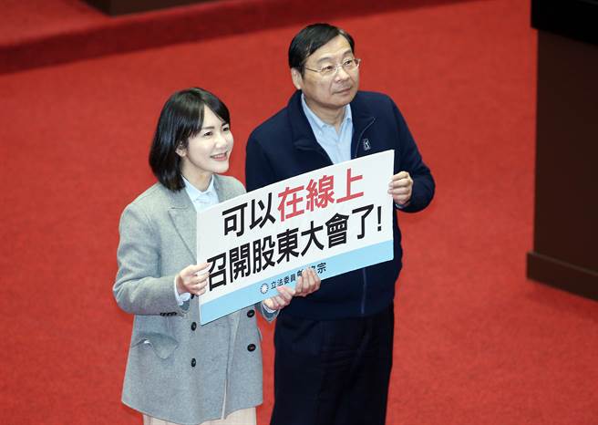 立法院14日院会三读通过「公司法部分条文修正草案」，开放公司得以用视讯方式召开股东会，立委曾铭宗（右）、谢衣凤（左）拿出标语在议场内合影留念。（姚志平摄）