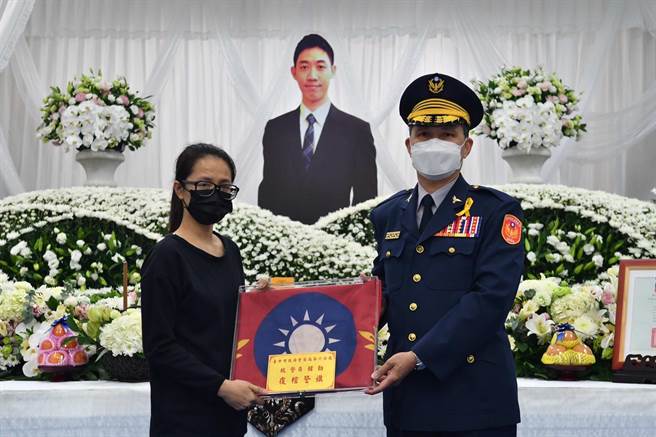 台中市警察局副局长林国清(右)转颁覆柩警旗予因公执勤英勇离世的韩姓员警家属。（民眾提供／卢金足台中传真）