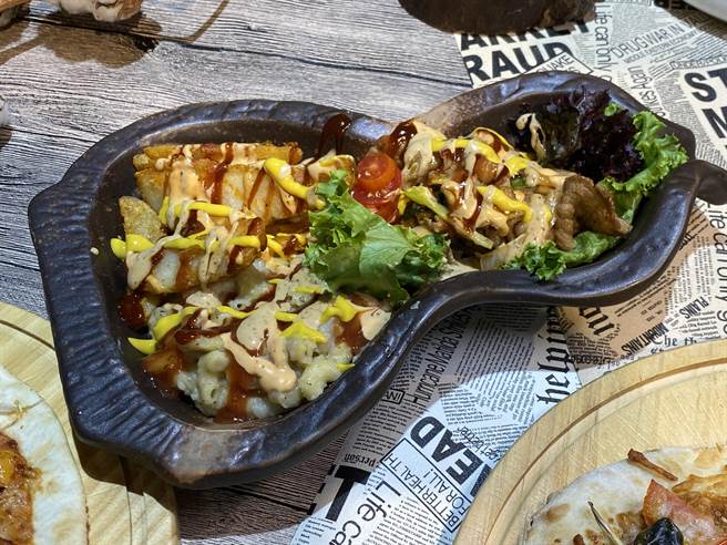 「垃圾Plate」是美式餐厅中一道经典菜，主要是将各类主食：如通心粉、马铃薯、炸薯条、肉类堆成小山，再淋上满满的不同酱汁。（冯惠宜摄）