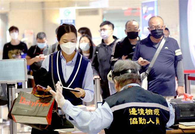 中央流行疫情指揮中心15日公布國內新增7例新冠肺炎境外移入確定病例，確診個案中新增1例死亡。在桃園機場入境管制區內，剛下機的旅客排隊查驗入境檢疫資料。（范揚光攝）（圖中非新聞當事人）
