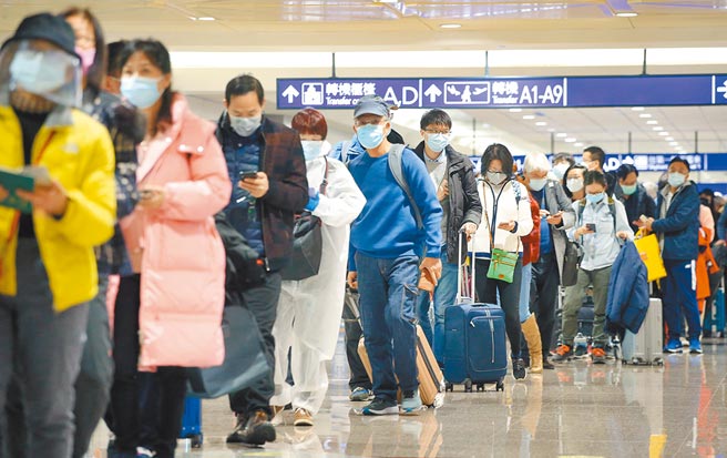 春節檢疫政策14日首日上路，吸引大批民眾返台，據中央流行疫情指揮中心統計，選擇方案C（7天自費入住集中檢疫所或防疫旅宿+7天在家居家檢疫+7天自主健康管理）的旅客佔多數，在桃園機場入境管制區內，剛下機的旅客排隊查驗入境檢疫資料。（范揚光攝）