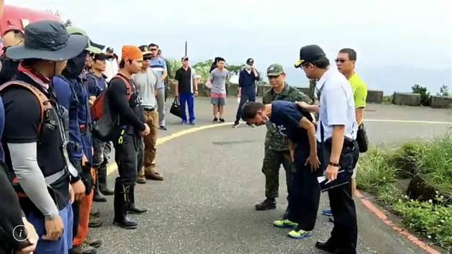 飛官少校吳彥霆的父親（右彎腰者）下車後救災人員鞠躬淚謝致敬。（本報資料照片，翻攝）