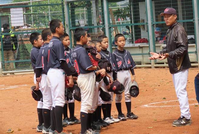 张耀腾（左）提醒小球员做完功课才能参加练球。（廖德修摄）