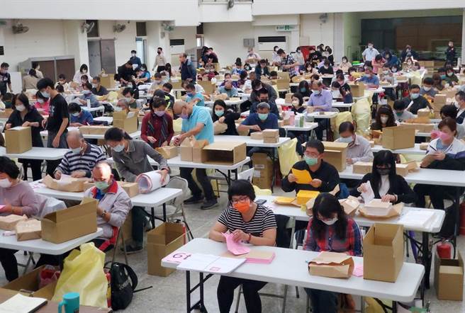 斗六市有82个投开票所、投票人数9万0244人是全县最多，本次未备点钞机辅助清点，全靠人工数选票，选务人员都全神贯注。（周丽兰摄）
