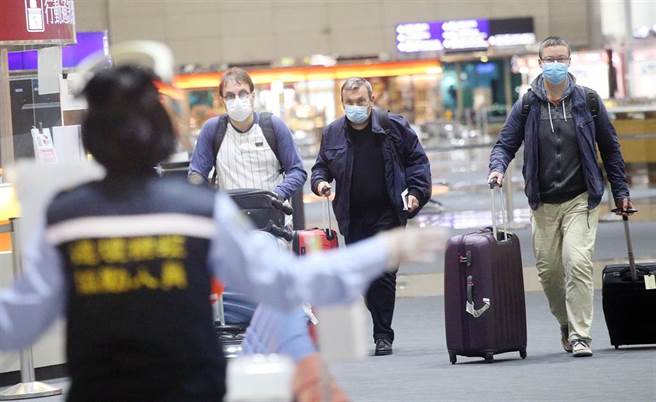 在桃機第二航廈入境大廳內，防疫人員引導剛入境的旅客準備採檢。（范揚光攝）（圖中非新聞當事人）
