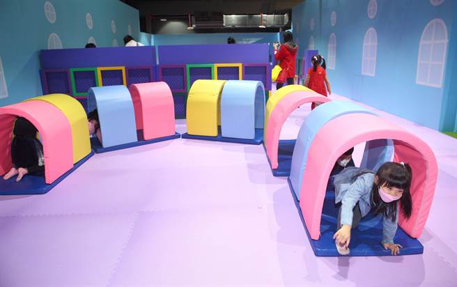 17日软垫游戏区内，小朋友们在平衡木、小火车及溜滑梯尽情玩耍。（张铠乙摄）