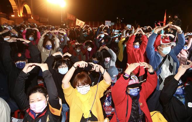 为拉高公投投票率，国民党17日在自由广场举办「民主守夜」活动，许多民眾不畏风寒前往参与，大家用手比出圈圈，做出同意的手势。（邓博仁摄）