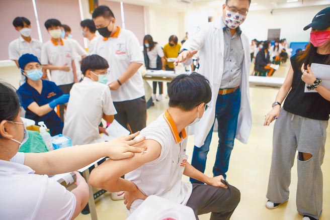 北市高中职开始施打第2剂BNT，有5803名高中生加入北市府主导的心肌炎研究，一旦发现异常，将立即通知学生就医。图为之前学生接种疫苗时，师长在旁安抚情绪。（本报资料照片）