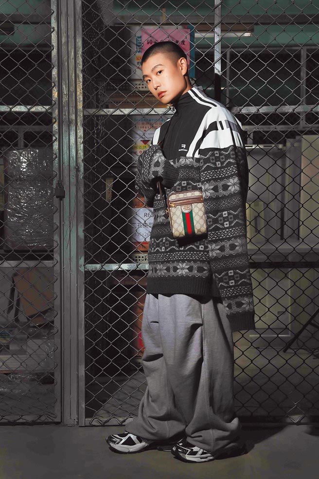 LEE身着Balenciaga winter21 collection系列运动裤4万4100元、造型毛衣，价格店洽，搭配The hacker project zip shoulder bag拉炼肩背包3万6900元，展现平时喜爱的时尚风格。（摄影／石智中‧妆髮／TED）