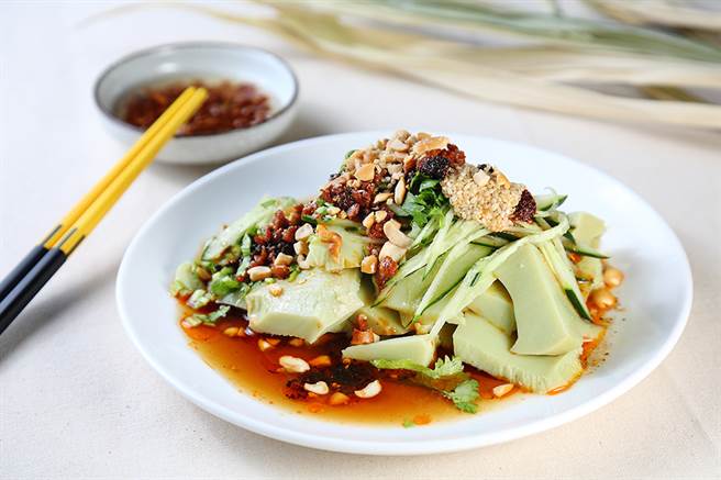 抹茶绿色的豌豆粉切成片状，迭上爽脆小黄瓜、香菜、以及花生碎，再淋上特制的辣椒油、芝麻油、蒜酥等酱料，清爽又开胃。(摄影/Carter)