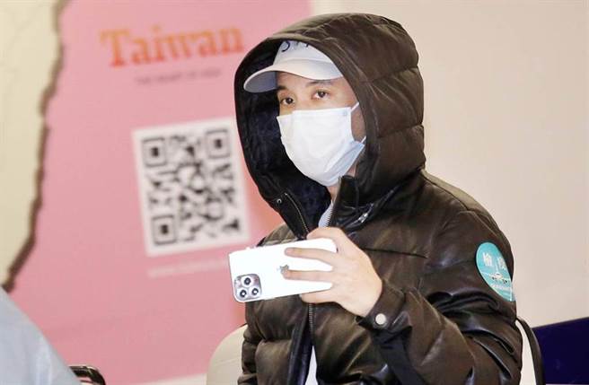王力宏下机后随即搭车前往筛检站採检，并拿起手机拍摄採访媒体。（范扬光摄）