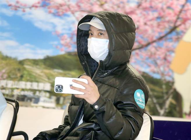 身陷離婚風暴的藝人王力宏18日搭機抵台，下機後隨即搭車前往篩檢站採檢，並拿起手機拍攝採訪媒體。（范揚光攝）