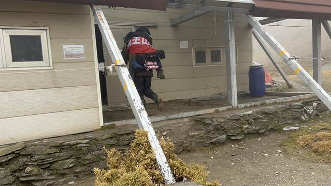 山友李女晕倒，高山协作前往背负患者至山屋取暖。（台中市消防局提供）