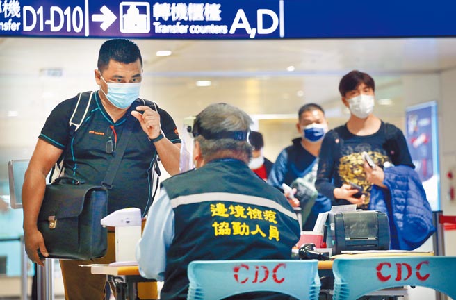 中央流行疫情指挥中心公布国内新增13例境外移入个案，其中有12人突破性感染。图为桃园机场入境管制区内，刚下机的旅客排队查验入境检疫资料。（范扬光摄）（图中非新闻当事人）