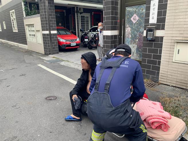 男主人自行从隔壁顶楼逃出，坐在消防救护担架上，不发一语。（民眾提供／谢琼云彰化传真）