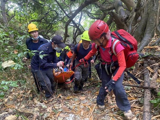 救难人员与消防局人员以简易卷式担架将李男固定后拉回路面、送医急救。（翻摄照片／袁庭尧高雄传真）