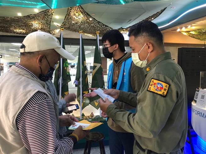 金门老兵志工穿着草绿服值勤，协助返金老兵申领专属礼。（金门县府观光处提供）
