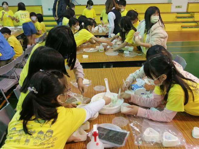 台中市北区赖厝国小学童利用有机米手作三角饭糰。（台中市农业局提供／王文吉台中传真）