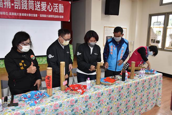 大湖乡长胡娘妹（左）、苗栗县青溪妇女协会理事长张淑芬（中）22日一同剖开竹钱筒。（谢明俊摄）