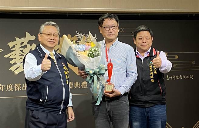 第十屆台中市表演藝術金藝獎由台灣揚琴樂團奪得，由台中市副市長令狐達榮（左）頒獎給團長鐘泉波（中）。（陳淑芬攝）