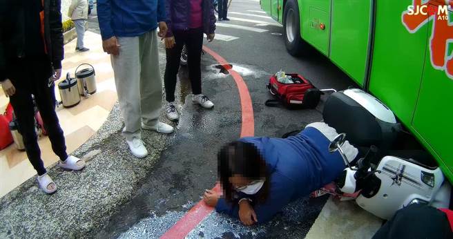 嘉義市自由路、保安路口今天發生大客車與機車擦撞，女機車騎士連人帶車被壓在大客車底。（讀者提供）