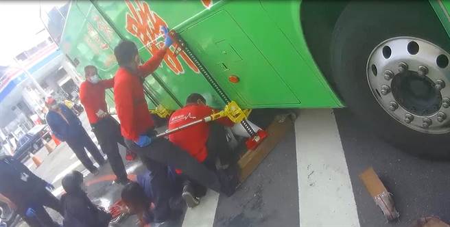 消防救護人員用Hi Lift手搖式千斤頂於機車兩旁頂撐大客車，再將受困的吳姓傷者救出。（讀者提供）