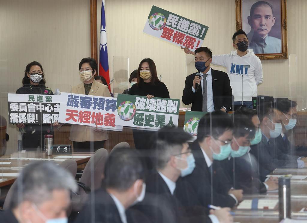 立法院院會21日通過民進黨團提案，將111年度中央政府總預算案自委員會中抽出逕付二讀，引發在野黨強烈不滿。圖為國民黨立委江啟臣（前右）22日在外交及國防委員會程序發言時，質疑人民監督政府預算的權力可以被糟蹋、霸凌到這種地步嗎？江並與立委馬文君（前右二）等人在會議室前高舉「民進黨！雙標黨！」、「破壞體制歷史罪人」等手舉牌抗議。（劉宗龍攝）