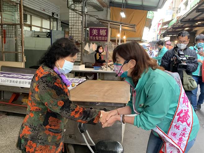 民進黨台中二選區立委補選候選人林靜儀(右)到大肚區自強市場掃街拜票，爭取選民支持。(林欣儀攝)