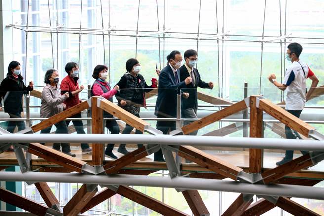 體超全人運動團隊育辰老師，帶著新光醫院院長侯勝茂（中左）、科教館館長劉火欽（中右），與長輩們一起在博物館之橋上練習正確健走姿勢。（鄧博仁攝）