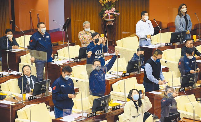 台北市议会蓝绿议员22日联手合作，以48票赞成、7票反对，否决「台北市重阳敬老礼金致送自治条例」覆议案，要求市府仍应发放重阳敬老金。表决时国民党籍市议员全体起立投下赞成票，市议员吴世正（中）更是振臂欢呼。（范扬光摄）